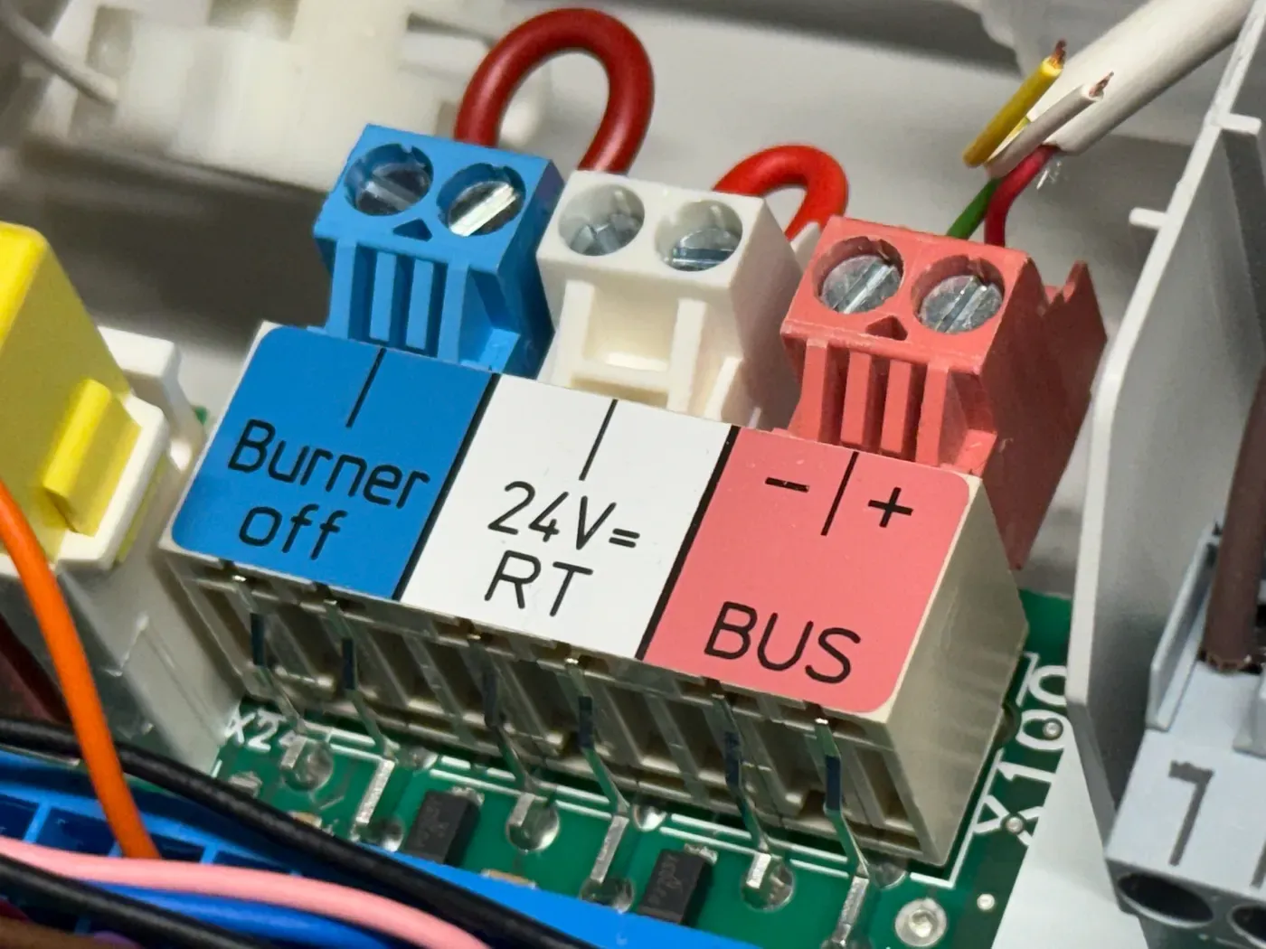 The Vaillant control board terminal strip, labelled “Burner off”, “24V= RT” and the red “− +” BUS pair