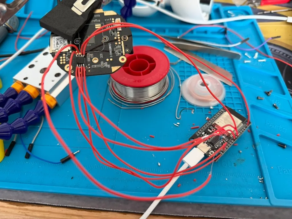 The whole rig: red leads from the flash running to a bare ESP32 on the mat