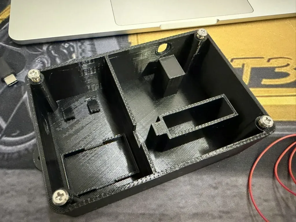 The printed case with the heat-set inserts pressed in and the barrier between the mains and low-voltage sides