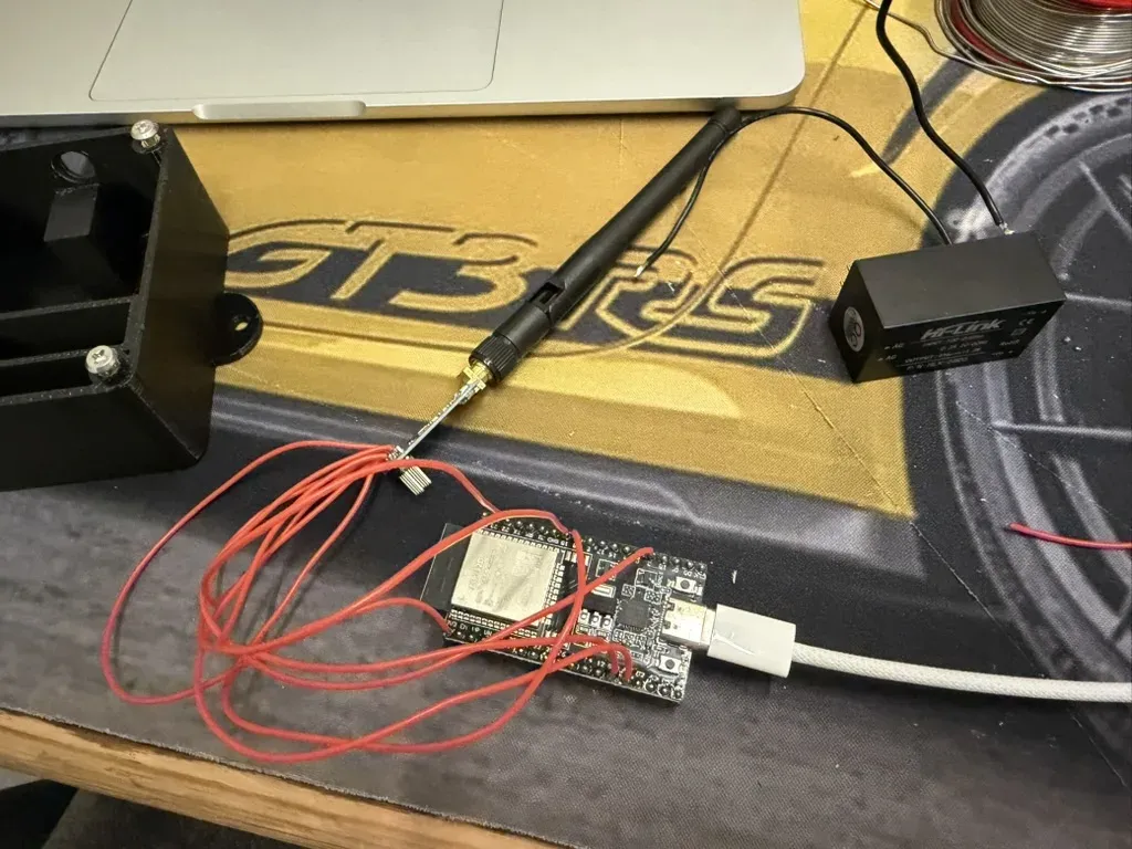 The parts on the desk: ESP32, CC1101 with its antenna, the Hi-Link supply and the printed case